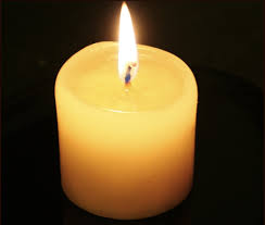 Small ivory pillar candle, lit.