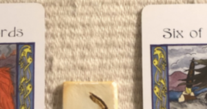 A teaser shot showing just the corners of two of the cards and one part of a rune.