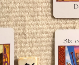 A teaser shot showing just the corners of the cards and one part of a rune from this week’s reading.