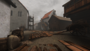 A screenshot from the video, showing a few buildings on a muddy street with some plank walkways laid across it.