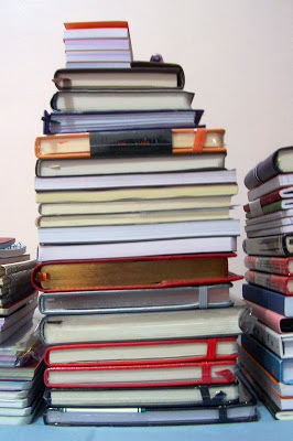 A stack of notebooks of various sizes and colors.