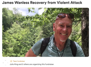 A photo of James Wanless smililng. He is outdoors, wearing his sunglasses on his head. Behind him is a beautiful, leafy green background.