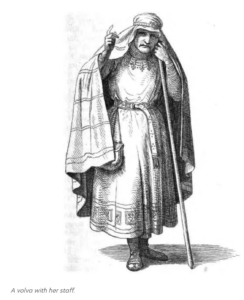 A black-and-white line drawing of a woman in medieval Norse clothing. Her right hand is raised, with her index finger pointing up. Her left hand holds her staff.