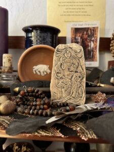 A roughly shaped tablet featuring images of Angrboda Hel Fenris and Jormungandr.